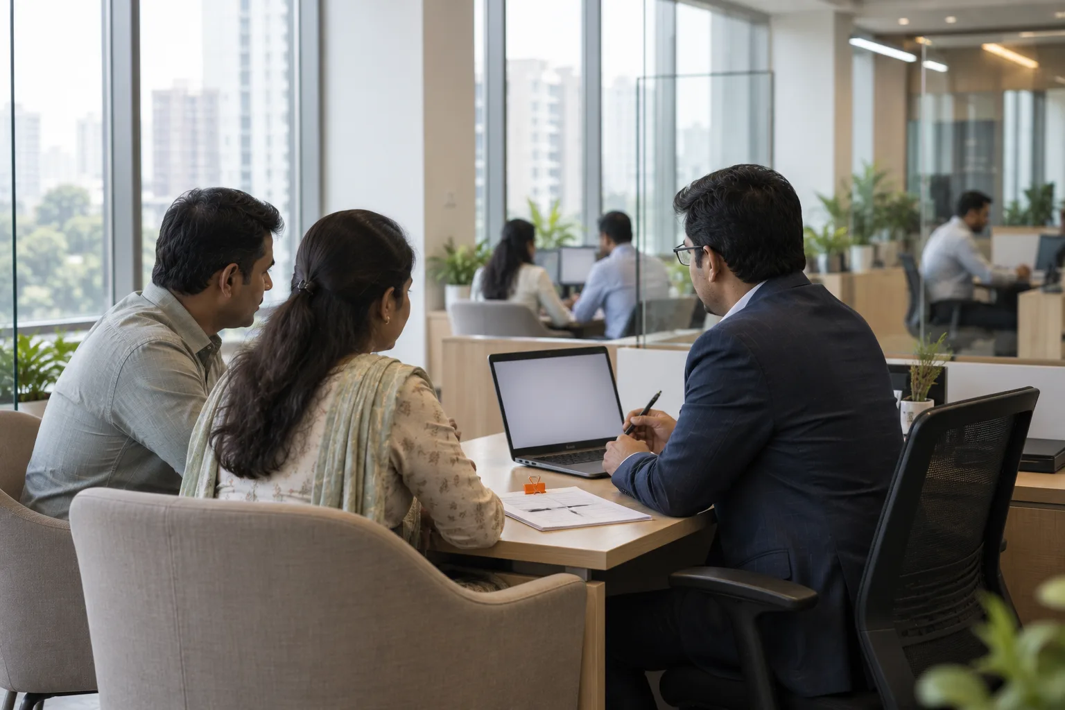 Advisor with two customers in an insurance branch meeting bay